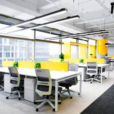 Open-plan office space with desks and city views